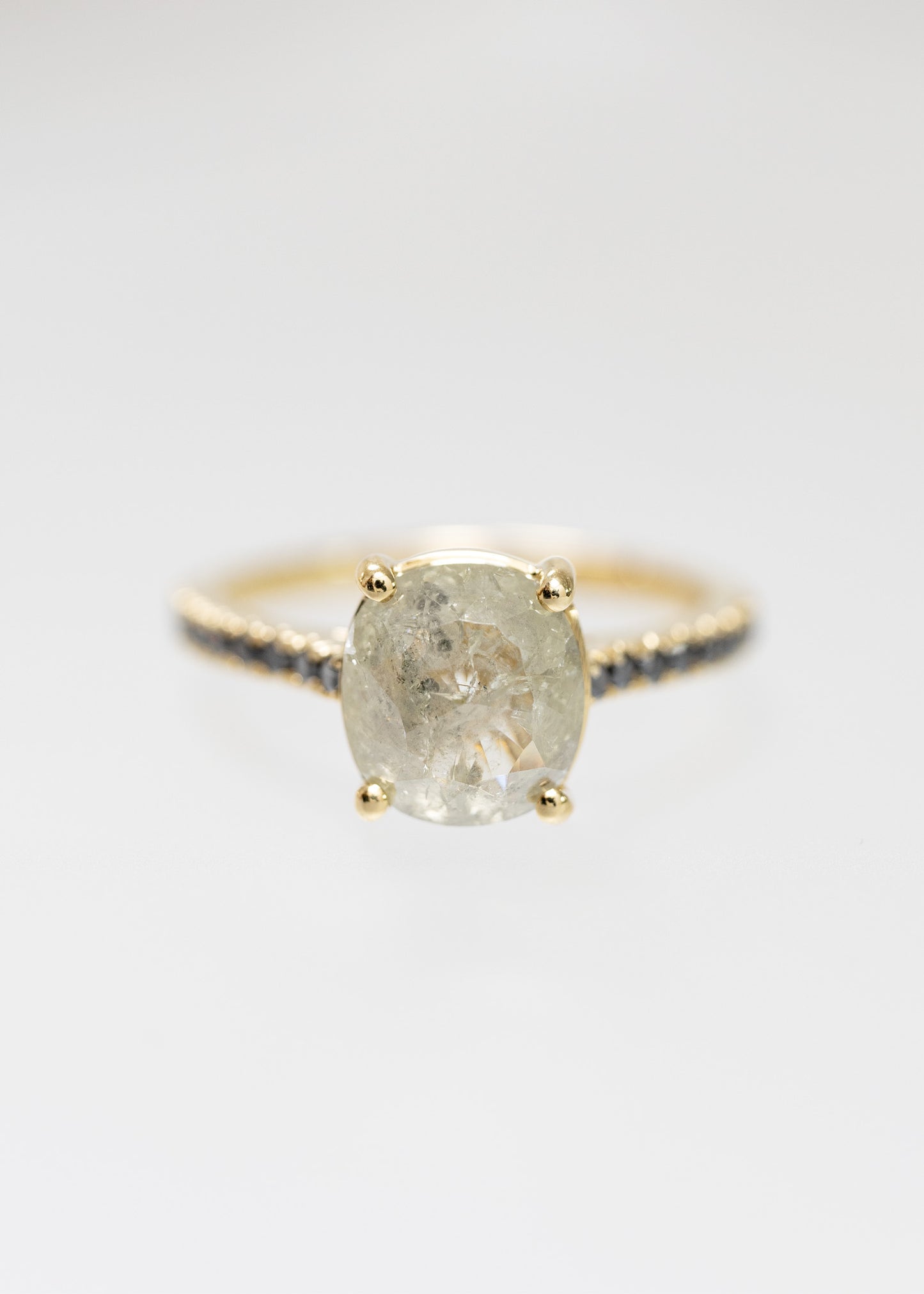 Cushion cut salt and pepper diamond solitaire engagement ring in 14K yellow gold with a black diamond pavé band