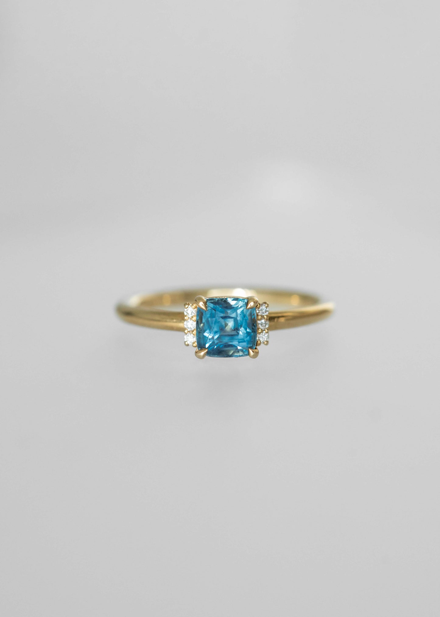 blue sapphire engagement ring, cushion cut sapphire ring, 18k yellow gold sapphire ring, modern solitaire ring, diamond accent engagement ring, ethical gemstone ring, colorful engagement ring, unique engagement rings