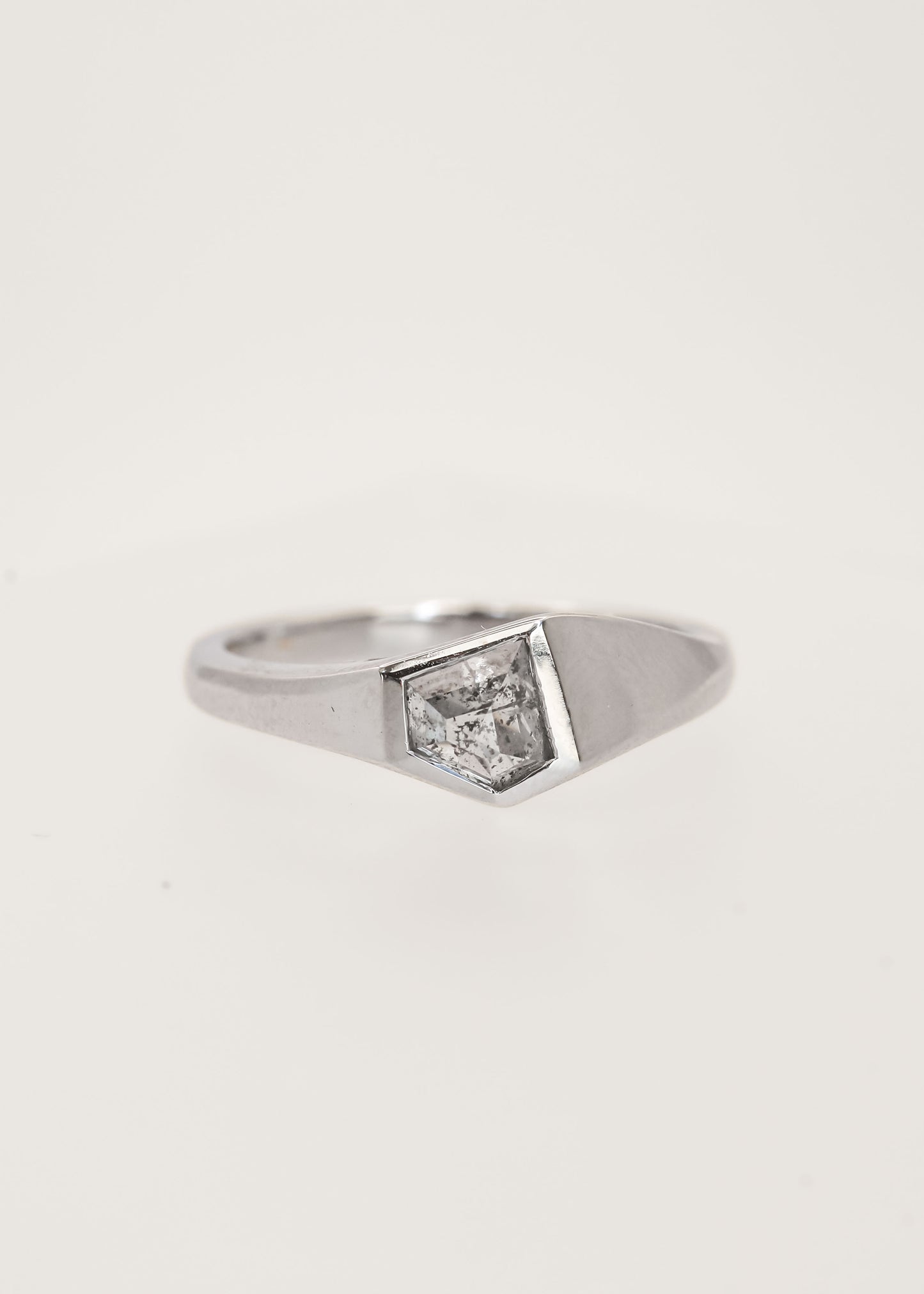 Gender neutral asymmetrical shield cut salt and pepper diamond signet engagement ring in 14K white gold with a full bezel