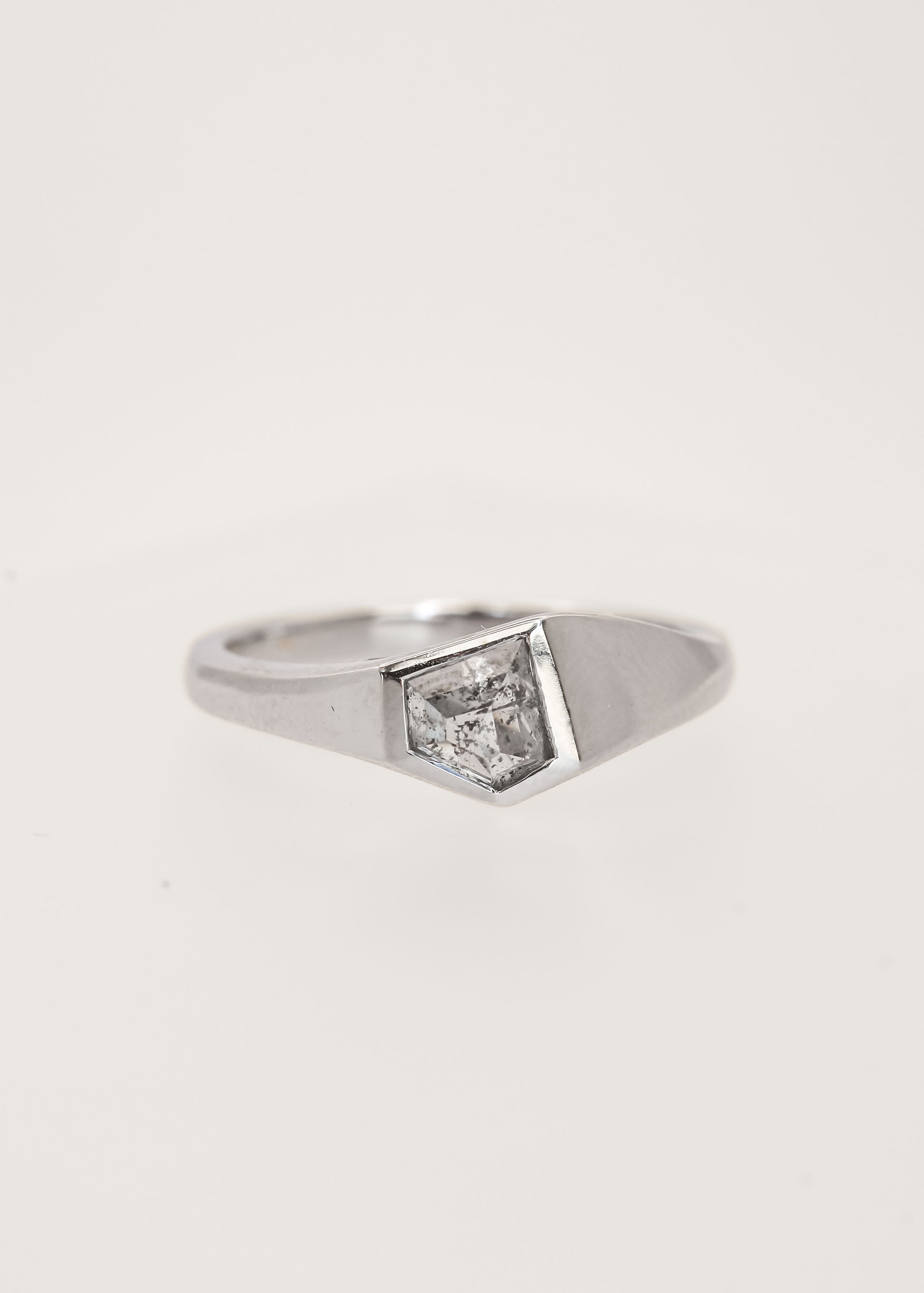 Gender neutral asymmetrical shield cut salt and pepper diamond signet engagement ring in 14K white gold with a full bezel
