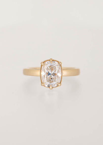 Elongated cushion moissanite solitaire engagement ring in 14K yellow gold with a six prong basket and milgrain detailing