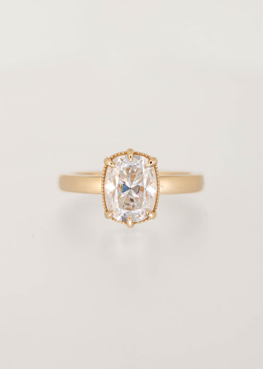 Elongated cushion moissanite solitaire engagement ring in 14K yellow gold with a six prong basket and milgrain detailing