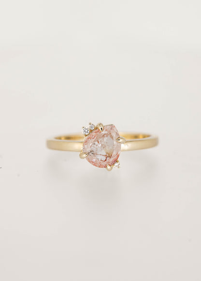 Dainty squatty pear salt and pepper diamond engagement ring in 14K yellow gold with a tilted four prong setting and two round diamond accents