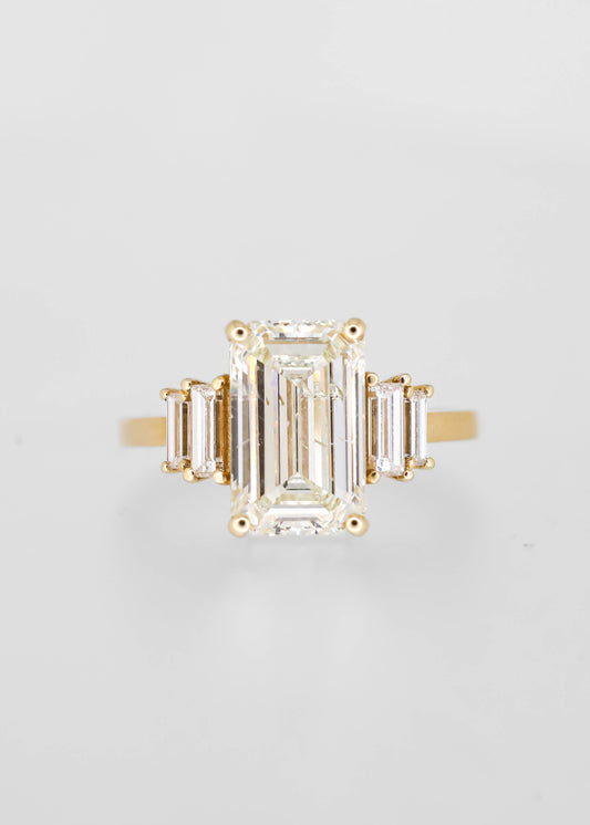 Emerald cut natural diamond five stone engagement ring in 14K yellow gold with stepped baguette side stones and a four prong center