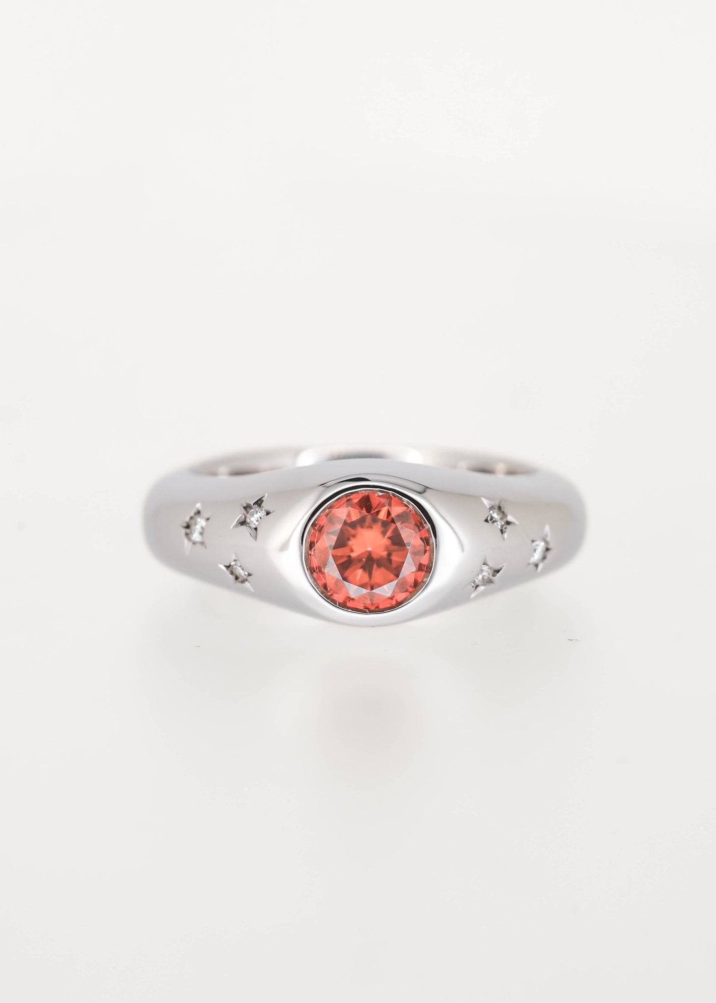 Gender neutral orange moissanite celestial signet engagement ring in 14K white gold with a full bezel and diamond-set star accents