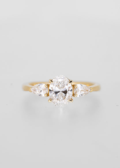 Classic oval cut lab grown diamond three stone engagement ring in 14K yellow gold with pear diamond side stones