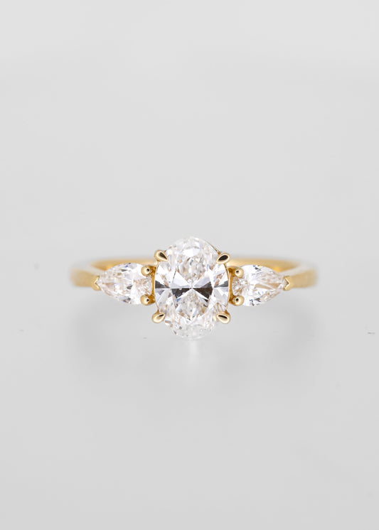 Classic oval cut lab grown diamond three stone engagement ring in 14K yellow gold with pear diamond side stones