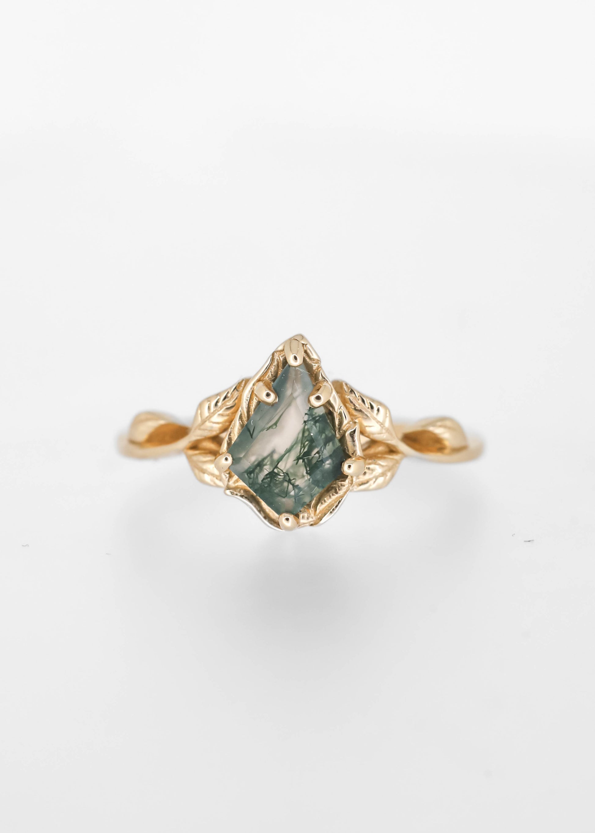 Nature inspired kite cut moss agate engagement ring in 14K yellow gold with leaf detailing and a twisted vine band