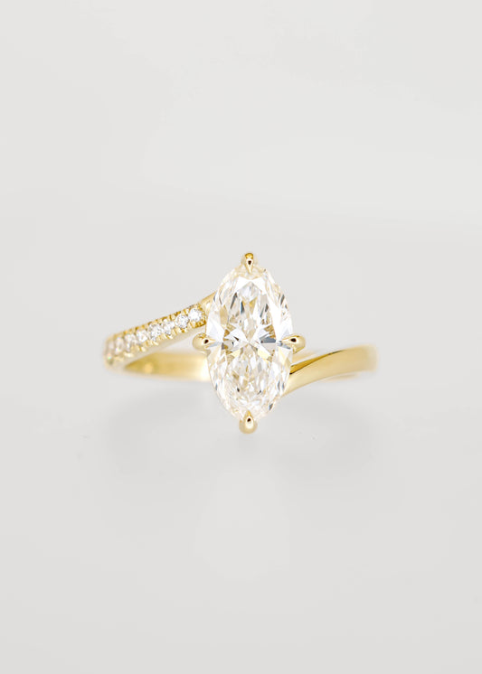 Moval cut lab grown diamond engagement ring in 14K yellow gold with an asymmetric bypass band and pavé accents