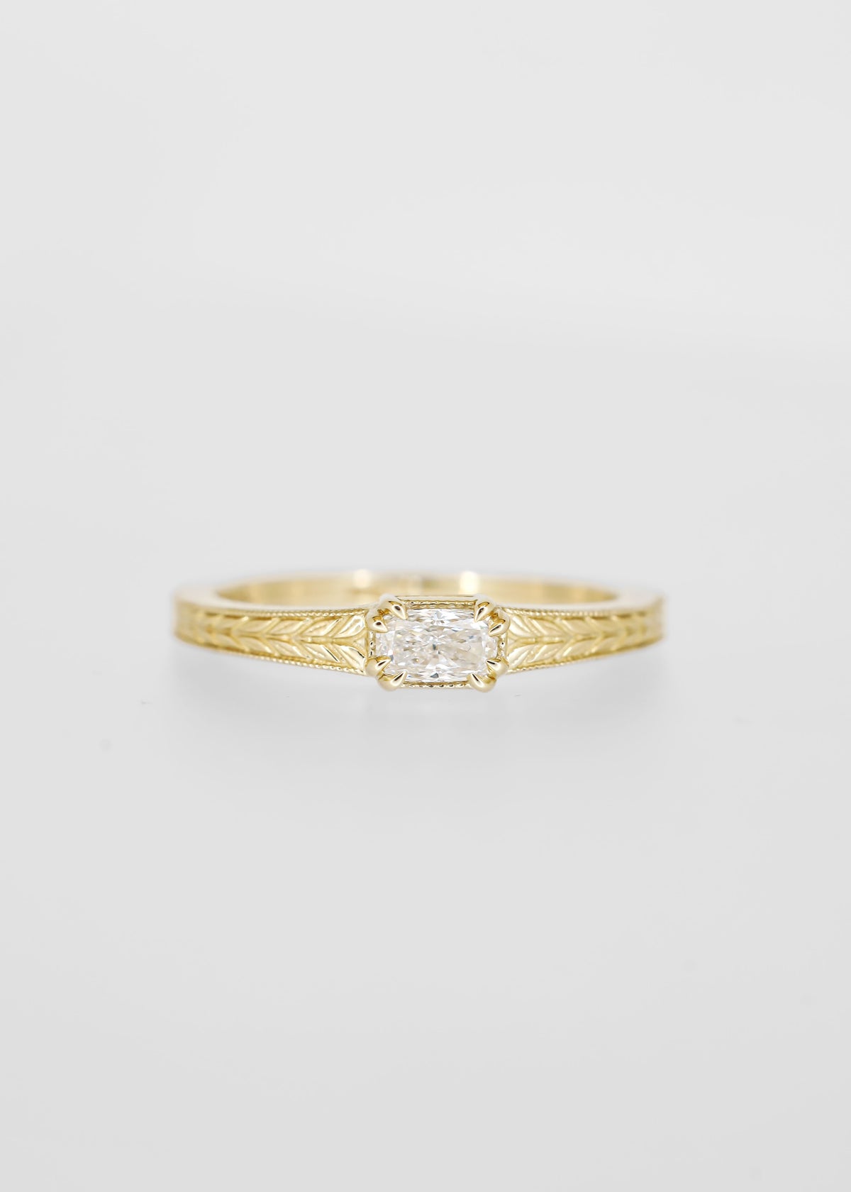 East west cushion cut lab grown diamond engagement ring in 14K yellow gold with milgrain and an engraved wheat band