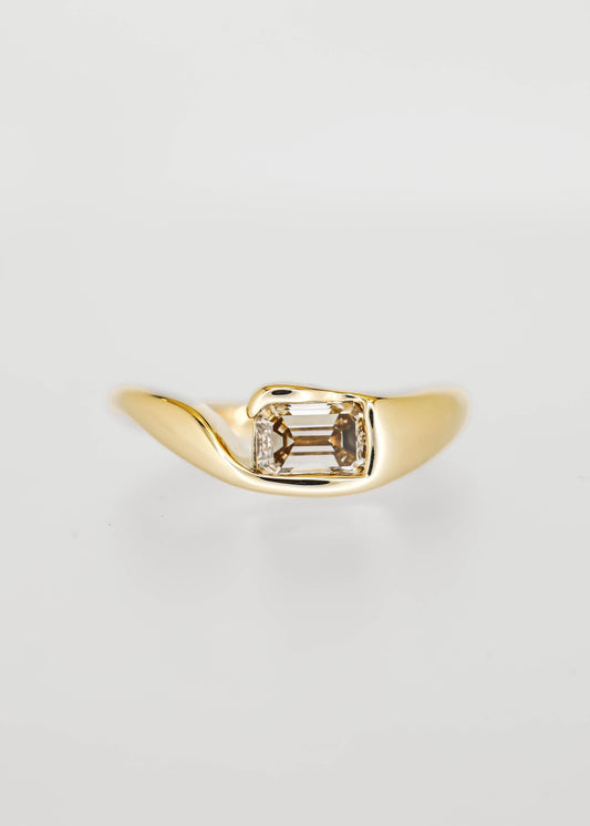 East west bezel set emerald cut champagne diamond engagement ring in 14K yellow gold with a sculptural molten band