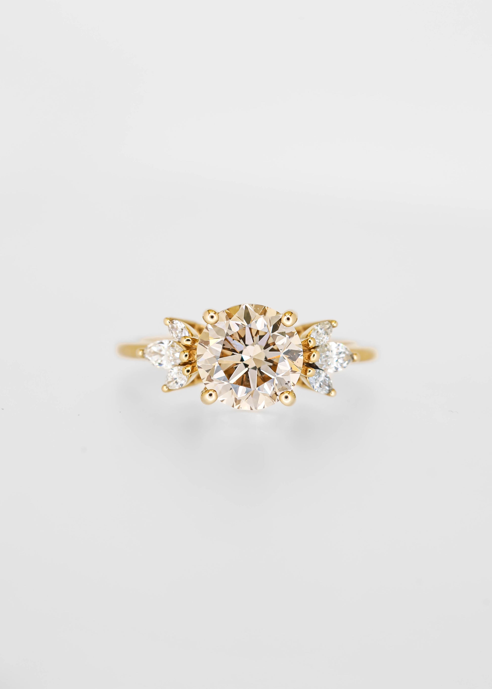 Round champagne diamond engagement ring in 14K yellow gold with marquise and pear diamond accent clusters