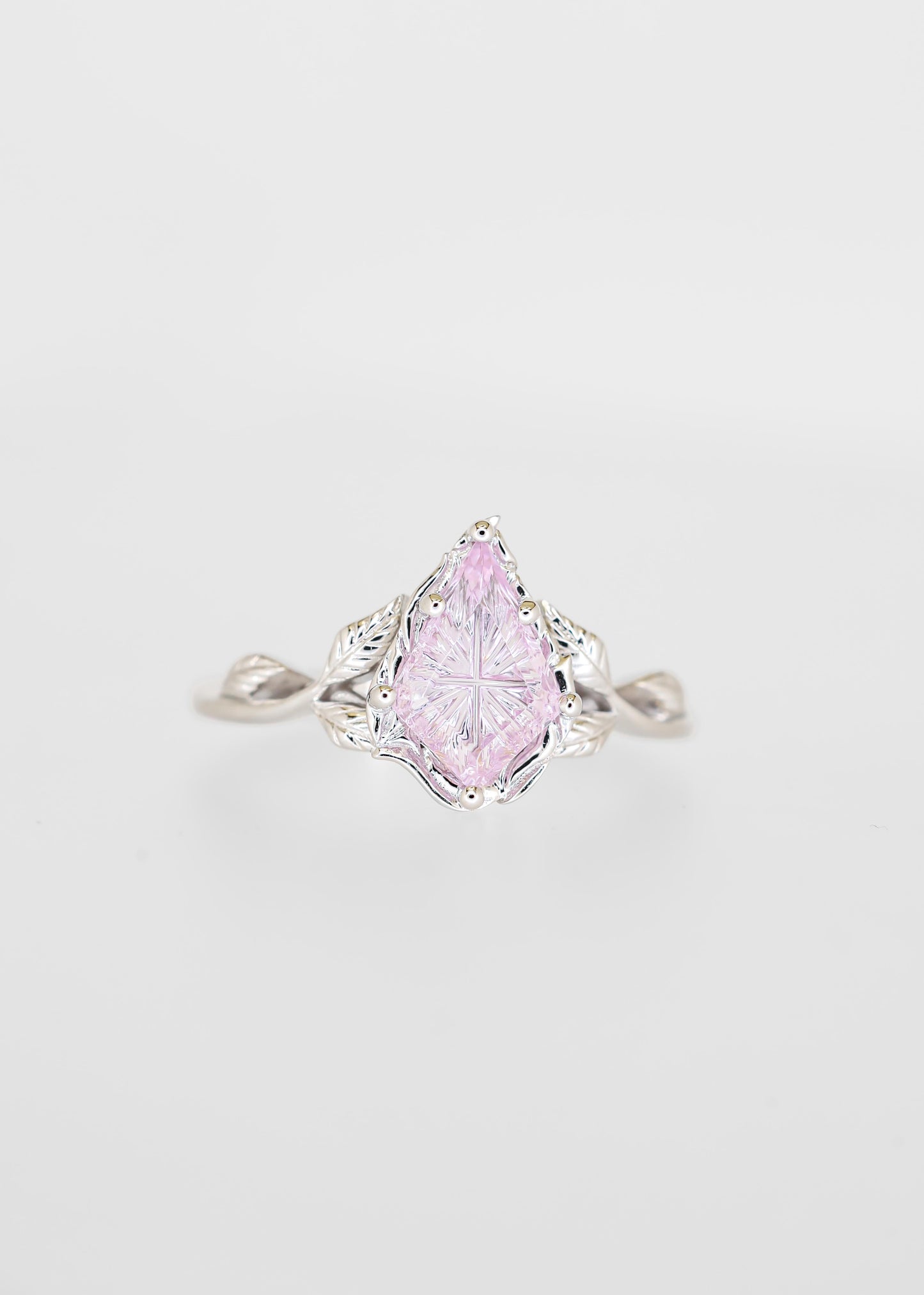 Starbright cut purple sapphire engagement ring in 14K white gold with a carved leaf gallery and twisted vine band