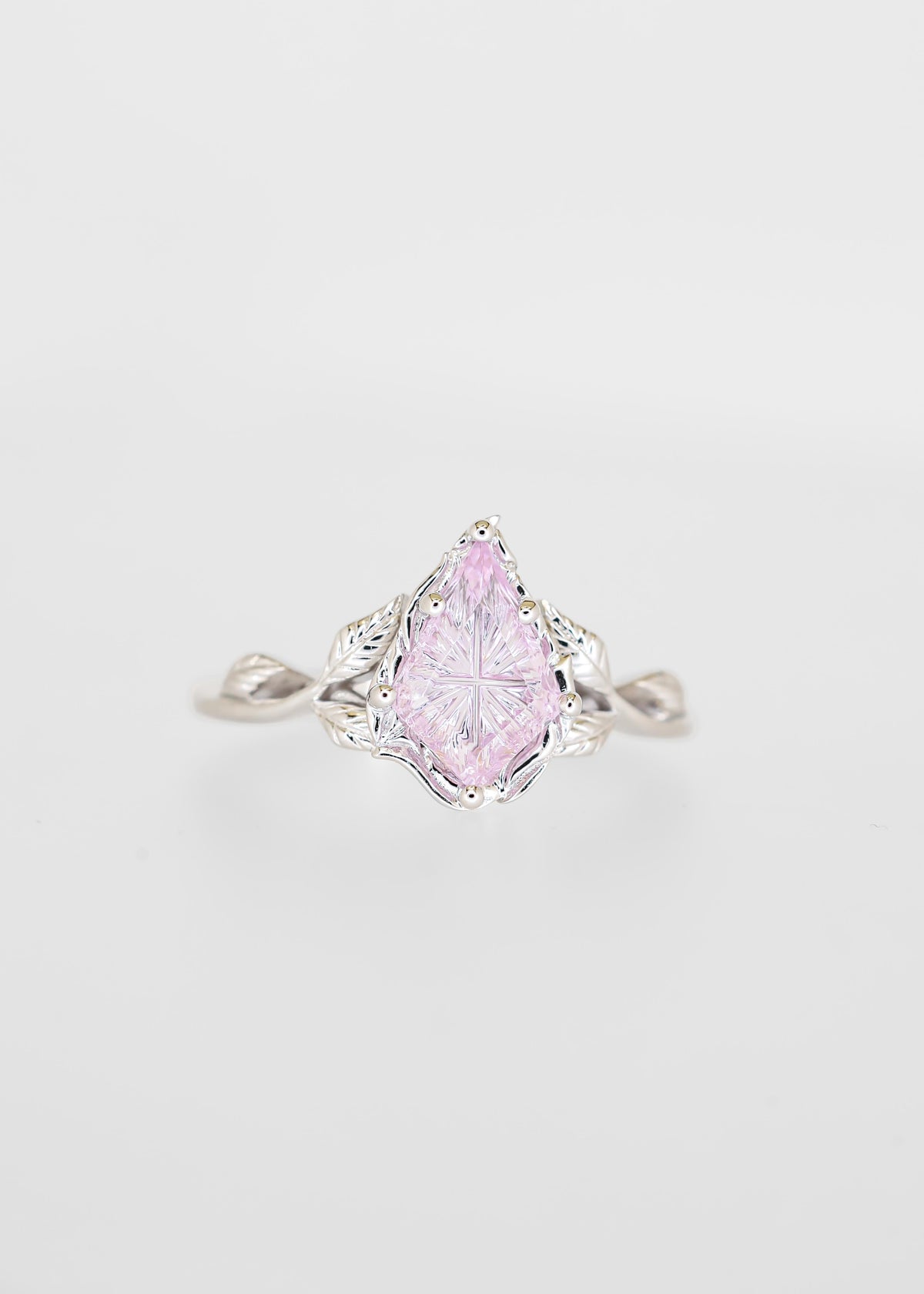 Starbright cut purple sapphire engagement ring in 14K white gold with a carved leaf gallery and twisted vine band
