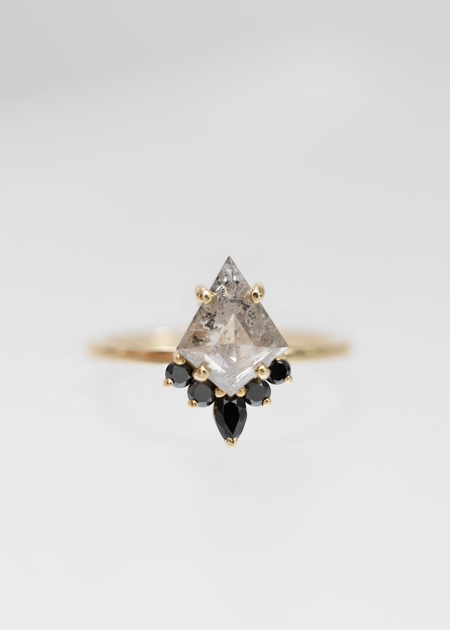 Kite cut salt and pepper diamond engagement ring in 14K yellow gold with a black diamond accent half-halo and pear accent