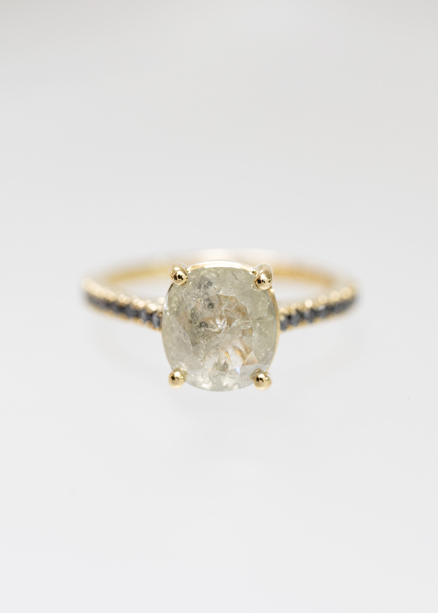 Cushion cut salt and pepper diamond solitaire engagement ring in 14K yellow gold with a black diamond pavé band