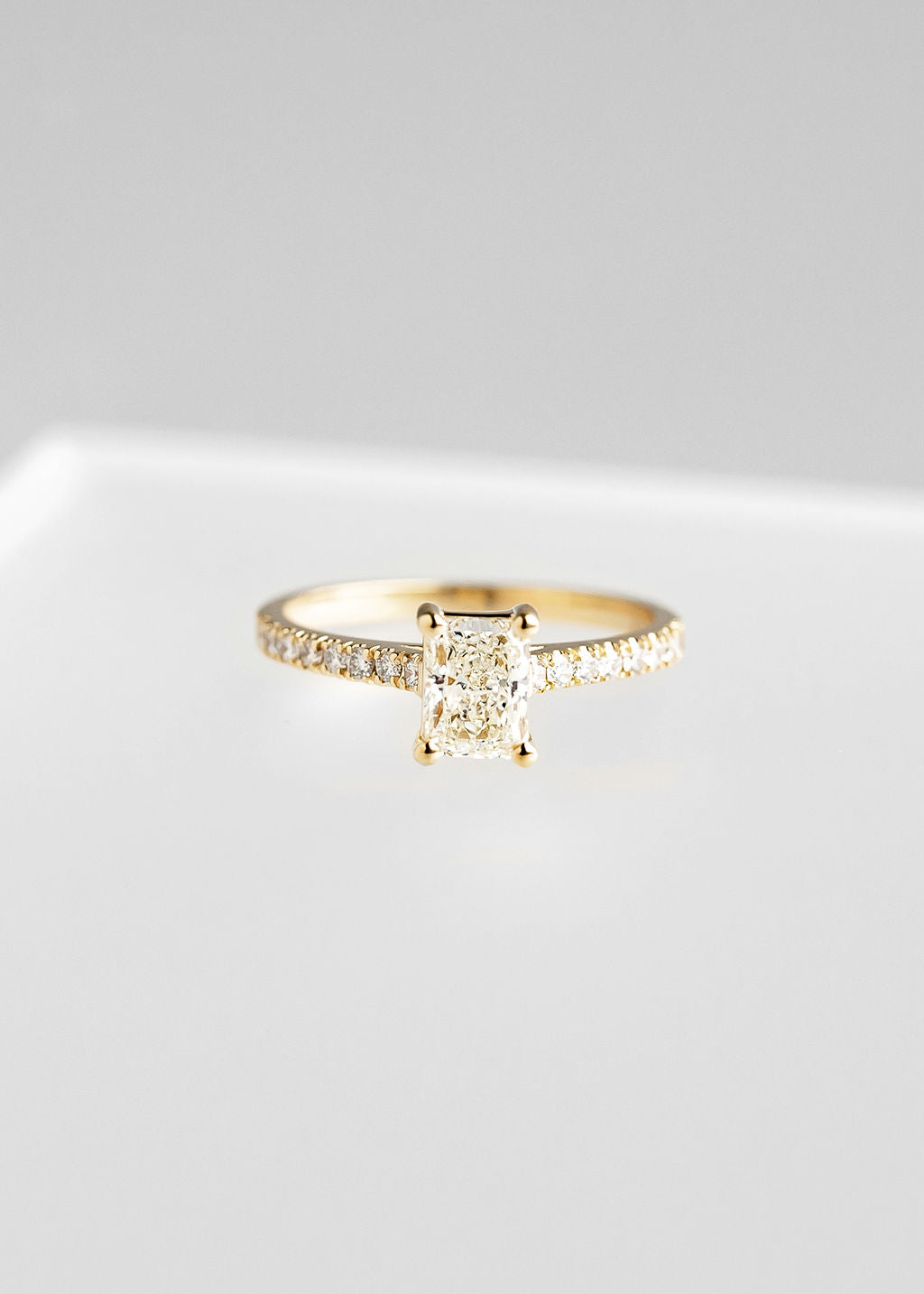 Radiant cut natural diamond solitaire engagement ring in 14K yellow gold with a pavé band