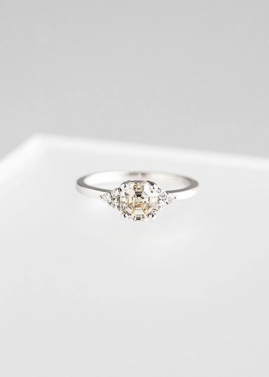 Octagon cut natural diamond engagement ring in 14K white gold with delicate three stone diamond clusters on each side