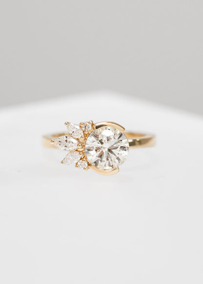 Round natural diamond engagement ring in 14K yellow gold with a half bezel and asymmetrical marquise and round diamond cluster