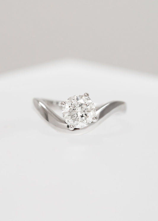 Asymmetrical round natural diamond solitaire engagement ring in 14K white gold with a modern curved band
