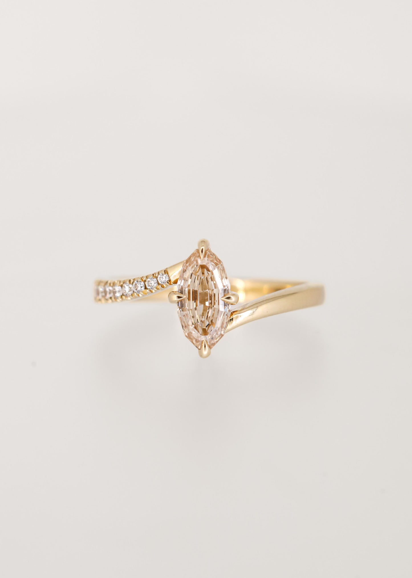 Step cut oval champagne diamond bypass engagement ring in 14K yellow gold with partial pavé and a north south setting