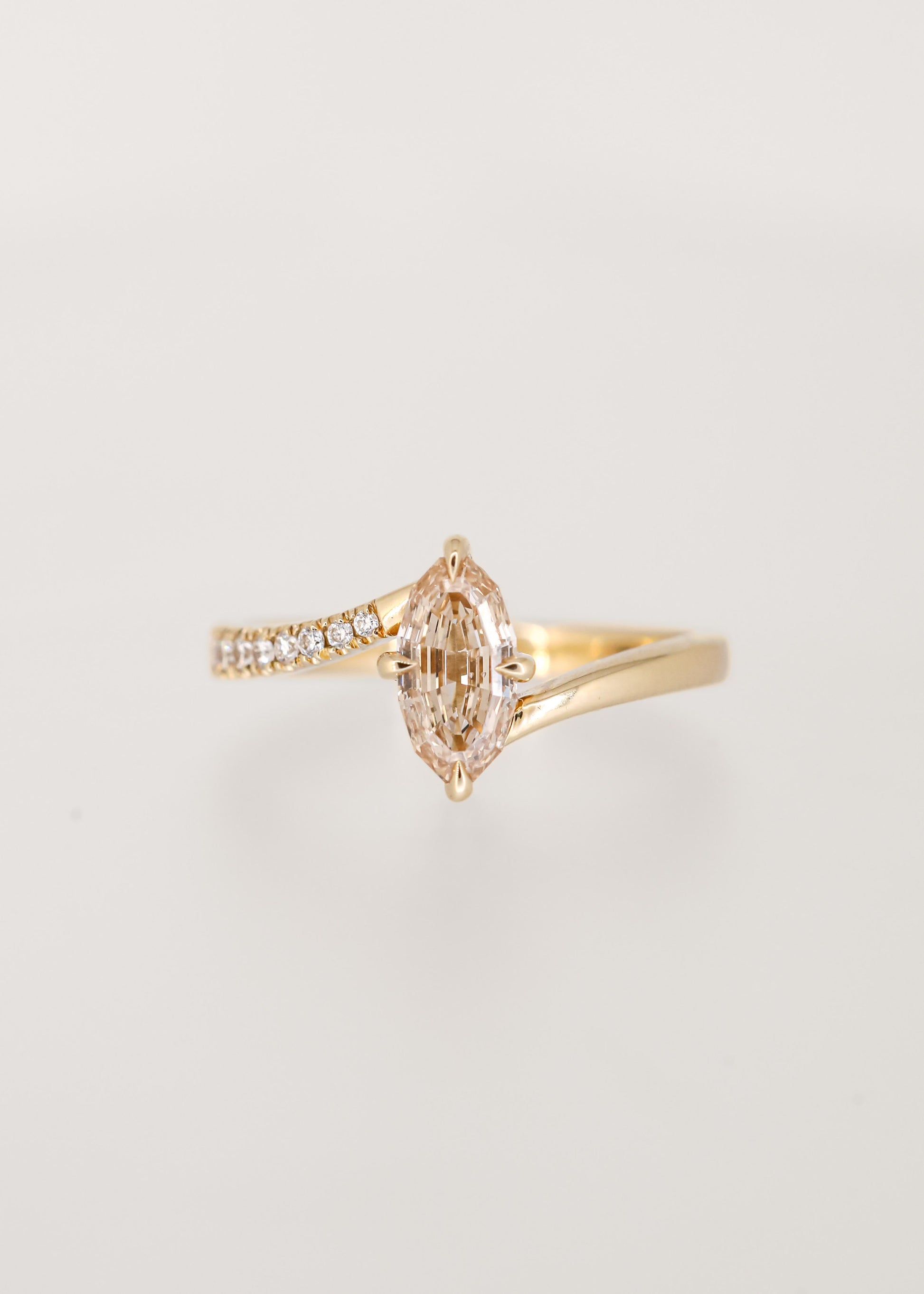 Step cut oval champagne diamond bypass engagement ring in 14K yellow gold with partial pavé and a north south setting