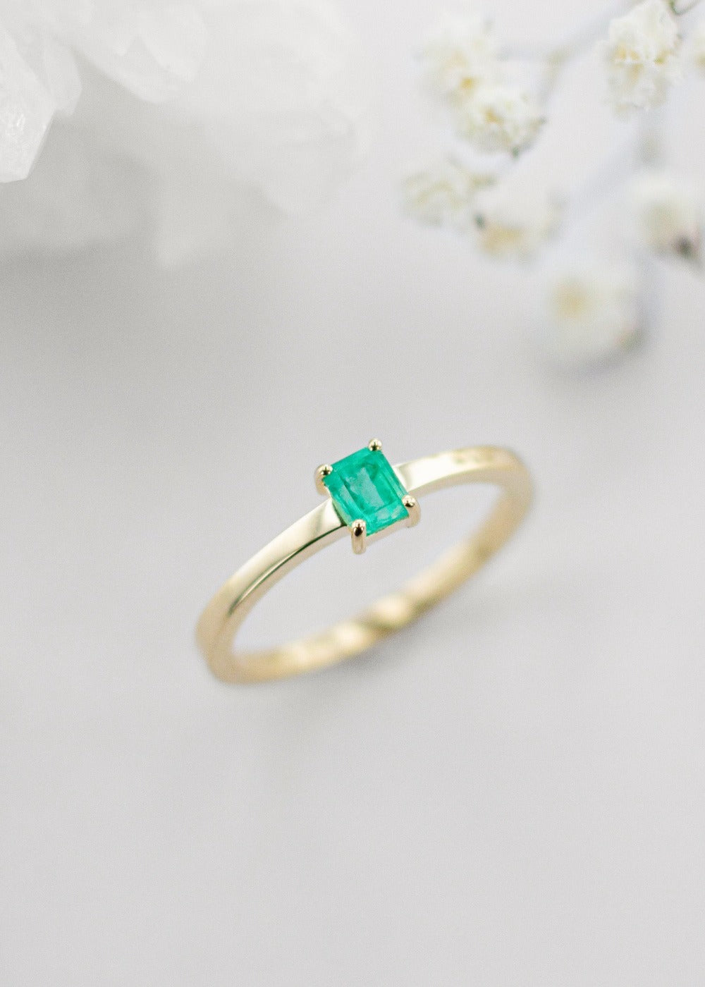 Our vega ring in yellow gold with a small emerald cut emerald. This super dainty ring is perfect for everyday wear!
